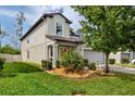 Charming two-story home with verdant grass, trimmed bushes, and a well-maintained lawn at 7034 Emerald Spring Loop, New Port Richey, FL 34653