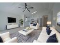 Open-concept living room with a modern ceiling fan and white couches and kitchen at 7551 52Nd N St, Pinellas Park, FL 33781