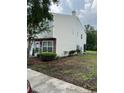 View of the townhome highlighting the siding and backyard landscaping at 7616 Colonial Ct, Tampa, FL 33615