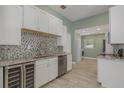 Modern kitchenette featuring white cabinets, stainless steel appliances, and stylish backsplash at 941 65Th S St, St Petersburg, FL 33707
