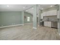 Open-concept living space with wood-look tile flooring and modern finishes creates a bright and airy atmosphere at 941 65Th S St, St Petersburg, FL 33707