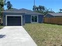 Blue home with a detached garage, sliding glass door, and a driveway at 1108 11Th S Ave, St Petersburg, FL 33705