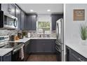 Modern kitchen with gray cabinets, stainless steel appliances, and quartz countertops at 11110 105Th Ave, Largo, FL 33778