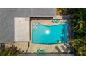 An aerial view of the backyard pool with ample patio space, lounge chairs and mature landscaping at 11110 105Th Ave, Largo, FL 33778