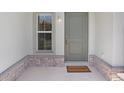 Inviting entryway with decorative stone and a welcome mat, adjacent to a window at 11742 Blackbrook Ct, Seffner, FL 33584