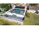 An aerial view of a fenced pool with a screened enclosure, a spacious deck, and lake access at 12416 Queensland Ln, Tampa, FL 33625