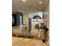 Modern kitchen with granite countertops, stainless steel appliances, and unique tree-themed art at 13313 Gasparilla Rd # 401, Placida, FL 33946