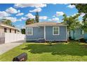Charming single-story home with a blue exterior, well-manicured lawn, and a decorative front door at 13325 1St E St, Madeira Beach, FL 33708