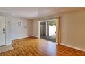 Bright living room featuring wood floors, sliding glass doors to outdoor patio, and neutral wall paint at 13755 Orange Sunset Dr # 101, Tampa, FL 33618