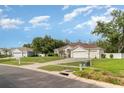 Single-story home with manicured lawn, long driveway, and attached two-car garage under blue sky at 14266 Creek Run Dr, Riverview, FL 33579