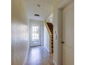 Neutral-toned entryway featuring tile flooring, a staircase, glass-paned door, and access to other rooms at 1531 Ember Ln, Tarpon Springs, FL 34689