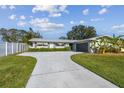 Charming single-story home featuring a grey garage door, well-manicured lawn and a long driveway leading to the entrance at 1701 62Nd S Ter, St Petersburg, FL 33712