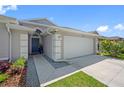 Home's entrance with a well-kept lawn, leading to a two-car garage at 19309 Garden Quilt Cir, Lutz, FL 33558