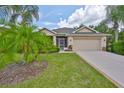 Well-maintained single-Gathering home boasts a manicured lawn, swaying palms, and a cozy screened porch at 2128 Worthington Greens Dr, Sun City Center, FL 33573
