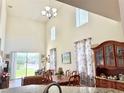 Open-concept dining room featuring soaring ceilings, a large window, and a classic wooden hutch, adjoining the living area at 2130 Broadway View Ave, Brandon, FL 33510