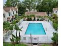 Overhead shot of a refreshing community pool surrounded by a secure fence and lush greenery at 2302 Maki Rd # 69, Plant City, FL 33563
