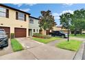 Well-maintained townhome featuring a single-car garage, landscaped lawn, and paved driveway at 2435 Edgewater Falls Dr, Brandon, FL 33511