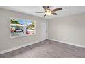 Bright living room featuring modern flooring, ceiling fan and neutral paint palette with a view of the parking lot at 24862 Us Highway 19 N # 1105, Clearwater, FL 33763