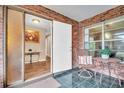 Welcoming screened entryway featuring brick accents and a cozy seating area at 2608 Camille Dr, Palm Harbor, FL 34684