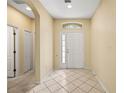 Bright foyer with tile flooring, a decorative window above the door, and ample natural light at 27353 Edenfield Dr, Wesley Chapel, FL 33544