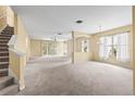 Spacious living room with neutral carpet, large windows with backyard views, and an open floor plan at 27353 Edenfield Dr, Wesley Chapel, FL 33544