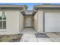 Covered front entry with a decorative stone detail, neutral paint, and white front door at 3058 Cara Ct, Palm Harbor, FL 34684