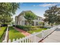 Charming townhouse featuring manicured lawn, brick walkway and white picket fence at 311 1St Sw Ave, Largo, FL 33770