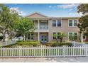 Inviting townhouse with a covered porch, balcony, and a charming white picket fence at 311 1St Sw Ave, Largo, FL 33770
