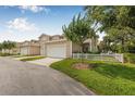 Townhouse with a two-car garage, adjacent to a well-maintained lawn and small tree at 311 1St Sw Ave, Largo, FL 33770