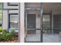 A screened front porch, featuring a black front door and manicured landscaping at 4004 Dream Oak Pl # 102, Tampa, FL 33613
