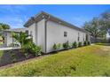 Well-maintained yard with lush landscaping along the side of the home, and a glimpse of an enclosed lanai at 403 Carriage House Ln, Tarpon Springs, FL 34688