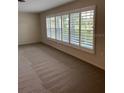Bright living room featuring neutral carpet and large windows with plantation shutters at 5281 Venetian Ne Blvd, St Petersburg, FL 33703