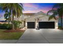 Beautiful home exterior with lush landscaping, a spacious driveway, and a basketball hoop at 5457 Sandy Shell Dr, Apollo Beach, FL 33572