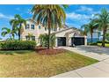 Well-maintained home with beautiful landscaping and palm trees in the front yard on a sunny day at 5457 Sandy Shell Dr, Apollo Beach, FL 33572