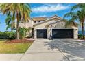 Charming two-story home features lush landscaping, a basketball hoop, and a spacious three-car garage at 5457 Sandy Shell Dr, Apollo Beach, FL 33572