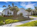 Beautiful home with a two-car garage and lush front yard featuring meticulously trimmed palm trees at 6211 114Th E Dr, Parrish, FL 34219