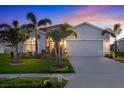 Beautiful single-story home with a two-car garage, palm trees, and a well-manicured lawn at 6211 114Th E Dr, Parrish, FL 34219