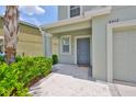 Inviting front entrance with a gray door, covered porch, and lush landscaping at 6512 Trent Creek Dr, Sun City Center, FL 33573