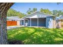 Cozy single-story home with a covered carport, showcasing a blue exterior and well-kept front yard surrounded by mature trees at 7065 73Rd N St, Pinellas Park, FL 33781