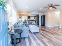 Inviting living room featuring new flooring, a cozy gray sofa, and seamlessly connected to the open kitchen and dining area at 7065 73Rd N St, Pinellas Park, FL 33781