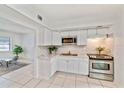 Bright kitchen featuring white cabinetry, stainless steel appliances, and a tile backsplash at 7313 Royal Palm Dr, New Port Richey, FL 34652