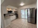 Well-lit kitchen featuring stainless steel appliances, sliding glass doors and ample natural light at 7313 Royal Palm Dr, New Port Richey, FL 34652