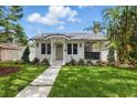 Charming home featuring a well-manicured lawn, fresh landscaping, and a welcoming walkway to the front door at 791 44Th N Ave, St Petersburg, FL 33703