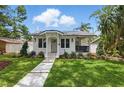 Charming home featuring a well-manicured lawn, fresh landscaping, and a welcoming walkway to the front door at 791 44Th N Ave, St Petersburg, FL 33703