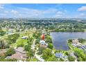 Aerial view showcasing a property with a pool on a picturesque lake, surrounded by lush greenery and neighborhood at 8127 Siquita Ne Dr, St Petersburg, FL 33702