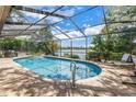 Relaxing screened-in pool with a jacuzzi offering beautiful lake views and a serene outdoor space for entertaining at 8127 Siquita Ne Dr, St Petersburg, FL 33702