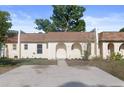 Charming townhouse featuring an arched entryway, fresh landscaping, and a spacious driveway at 9831 83Rd Way, Seminole, FL 33777