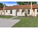 Charming townhouse featuring an arched entryway, fresh landscaping, and a spacious driveway at 9831 83Rd Way, Seminole, FL 33777