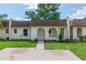 Charming single-story home with a well-maintained lawn, arched entryway, and light yellow exterior at 9831 83Rd Way, Seminole, FL 33777