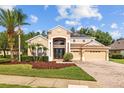 Beautiful two-story tan house with a three-car garage, manicured lawn and solar panels at 10646 Cory Lake Dr, Tampa, FL 33647